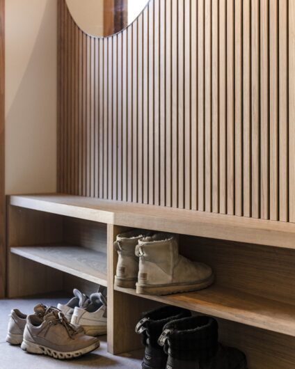 Spesialbygget løsning til gang med spiler på vegg, bygget av møbelsnekker. Sko plassert i skohylle og på gulv.